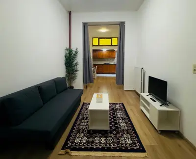 a living room with a blue couch and a tv at The Brussels Nest in Brussels
