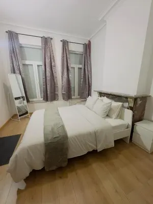 a bedroom with a large white bed and a chair at The Brussels Nest in Brussels