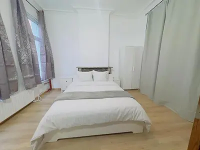 a white bedroom with a large bed with white sheets at The Brussels Nest in Brussels