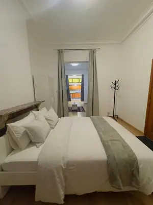 a bedroom with a large bed with white sheets and pillows at The Brussels Nest in Brussels