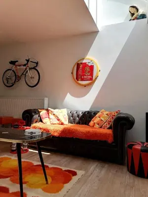 a living room with a couch and a bike on the wall at Unique renovated chapel in Temse