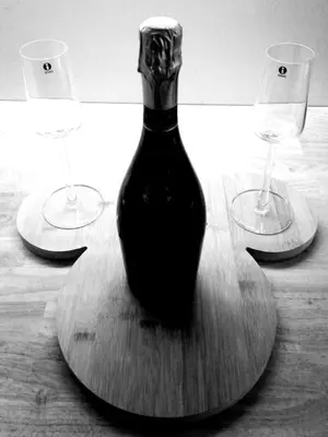 a bottle of wine on a wooden table with two wine glasses at Unique renovated chapel in Temse