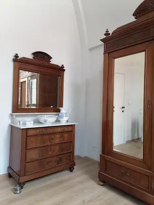a wooden dresser with a mirror and a wooden cabinet at Unique renovated chapel in Temse