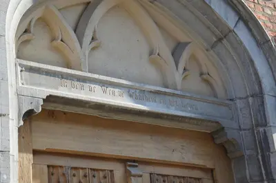 a wooden door with a sign on top of it at Unique renovated chapel in Temse
