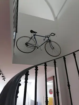 a bike hanging on the wall in a room at Unique renovated chapel in Temse