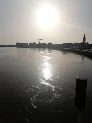 a black and white photo of a river with the sun at Unique renovated chapel in Temse