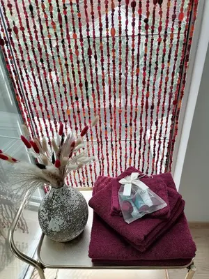a table with purple towels and a vase with a flower at Unique renovated chapel in Temse