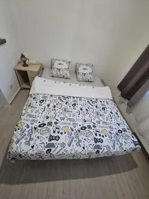 a bedroom with a bed with a black and white comforter at Large 1st floor apartment, Schaerbeek, Brussels in Brussels