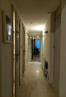 a hallway with a long corridor with a tv on a wall at Large 1st floor apartment, Schaerbeek, Brussels in Brussels
