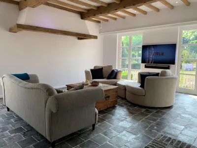 a living room with two couches and a flat screen tv at The Oak & Squirrel Villa in Hoogstraten