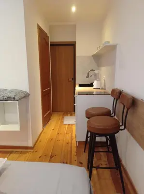 a small kitchen with two stools in a room at Cozy and centrally located studio apartment in Brussels