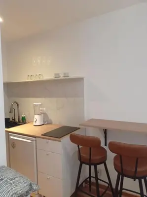 a kitchen with two bar stools and a counter at Cozy and centrally located studio apartment in Brussels