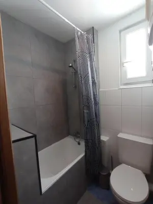 a bathroom with a tub and a toilet and a shower at Cozy and centrally located studio apartment in Brussels