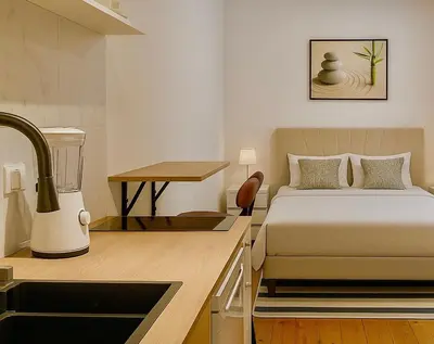 a bedroom with a bed and a kitchen with a sink at Cozy and centrally located studio apartment in Brussels