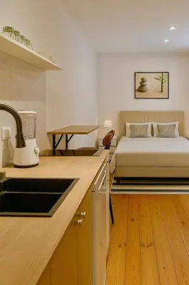 a kitchen and bedroom with a bed in a room at Cozy and centrally located studio apartment in Brussels