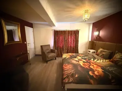 a hotel room with a bed and a chair at Logies Het Koetshuis in Herentals