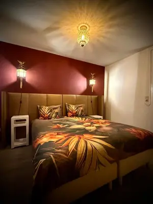 a bedroom with a large bed with red walls at Logies Het Koetshuis in Herentals