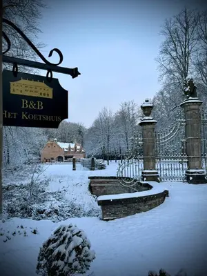 a fence covered in snow with a sign on it at Logies Het Koetshuis in Herentals