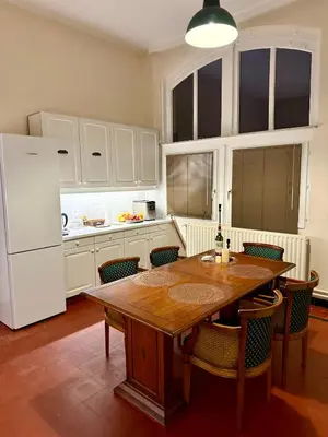 a kitchen with a wooden table and a white refrigerator at Logies Het Koetshuis in Herentals