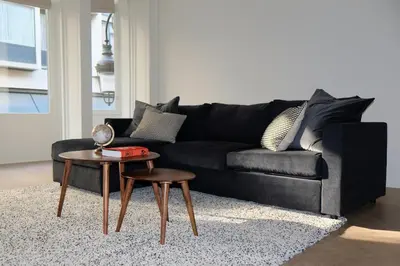 a black couch sitting in a living room with a table at Brussels center spacious and central apartment in Brussels
