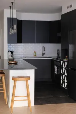 a kitchen with black cabinets and a counter and stool at Brussels center spacious and central apartment in Brussels