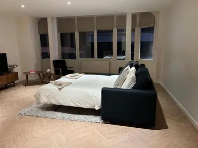 a large bedroom with a bed and a couch at Brussels center spacious and central apartment in Brussels