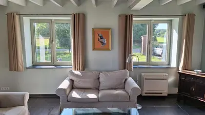 a living room with a couch and two windows at Peaceful Countryside Escape for Leisure or Work, Near Brussels in Dilbeek