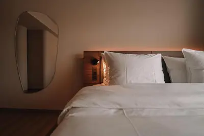 a bedroom with a white bed with a mirror at SKIPR Hotel - adults only in Antwerp