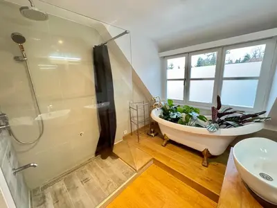a bathroom with a tub and a shower and a sink at La Chanterelle in Wavre