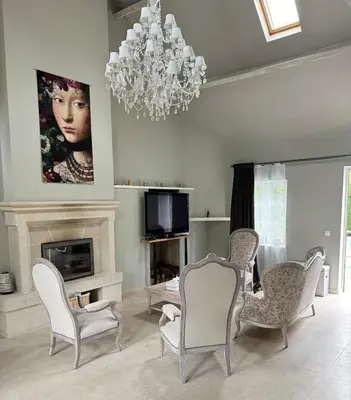 a living room with chairs and a chandelier at La Chanterelle in Wavre