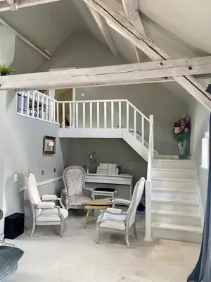 a living room with a staircase and a table and chairs at La Chanterelle in Wavre