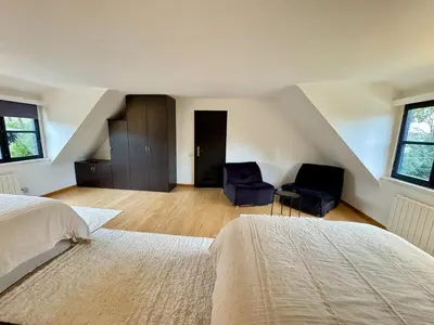 a bedroom with two beds and two chairs at La Chanterelle in Wavre
