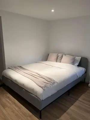 a bed with white sheets and pink pillows at Studio in Brussels in Brussels