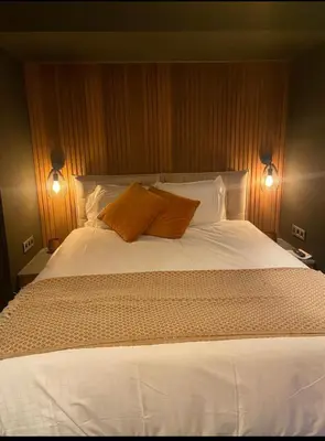 a bedroom with a large bed with two orange pillows at Dtoxx Waasmunster in Waasmunster