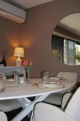 a dining room with a white table and a mirror at B&B by Delizia met mogelijkheid tot bijhuren van privé wellness in Rumst
