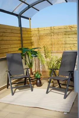 two chairs sitting on a patio with plants at B&B by Delizia met mogelijkheid tot bijhuren van privé wellness in Rumst