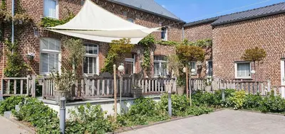 a white umbrella in front of a brick building at Guesthouse Biolleke in Boutersem