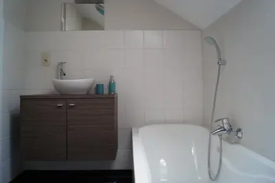 a bathroom with a tub and a sink and a bath tub at Guesthouse Biolleke in Boutersem