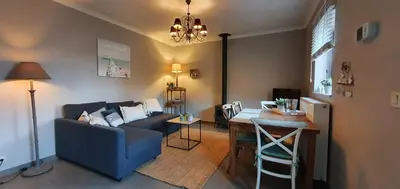 a living room with a blue couch and a table at Guesthouse Biolleke in Boutersem