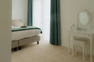 a bedroom with a bed and a mirror and a table at Boutique Guesthouse - Private Top floor - 3 rooms - host on site available in Ghent