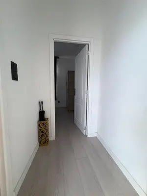 an empty hallway with white walls and wooden floors at Hôtel Garden's jacuzzi spa 1 in Brussels