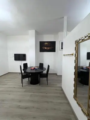 a dining room with a table and chairs and a mirror at Hôtel Garden's jacuzzi spa 1 in Brussels