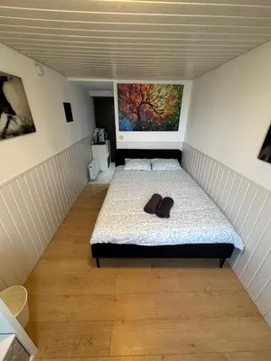 a bedroom with a bed with a pair of shoes on it at Studio individuel in Dilbeek