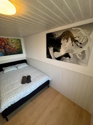 a bedroom with a bed with a painting on the wall at Studio individuel in Dilbeek