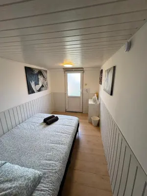 a small bedroom with a bed and a window at Studio individuel in Dilbeek