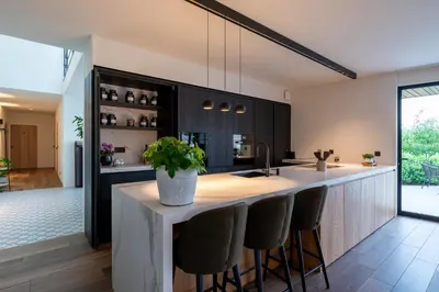 a kitchen with a island with bar stools at Logies De Hoeven in Kasterlee