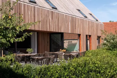 an external view of a building with tables and chairs at Logies De Hoeven in Kasterlee