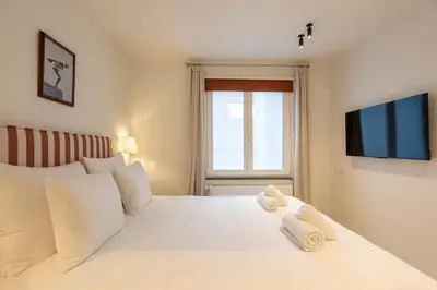 a bedroom with a white bed with towels on it at SHWAY - The Second Mate's Glance in Antwerp