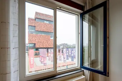 a window with a view of a building at SHWAY - The Second Mate's Glance in Antwerp
