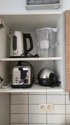 a cupboard with a toaster a blender and other kitchen items at Royal sleeping Brussels in Brussels